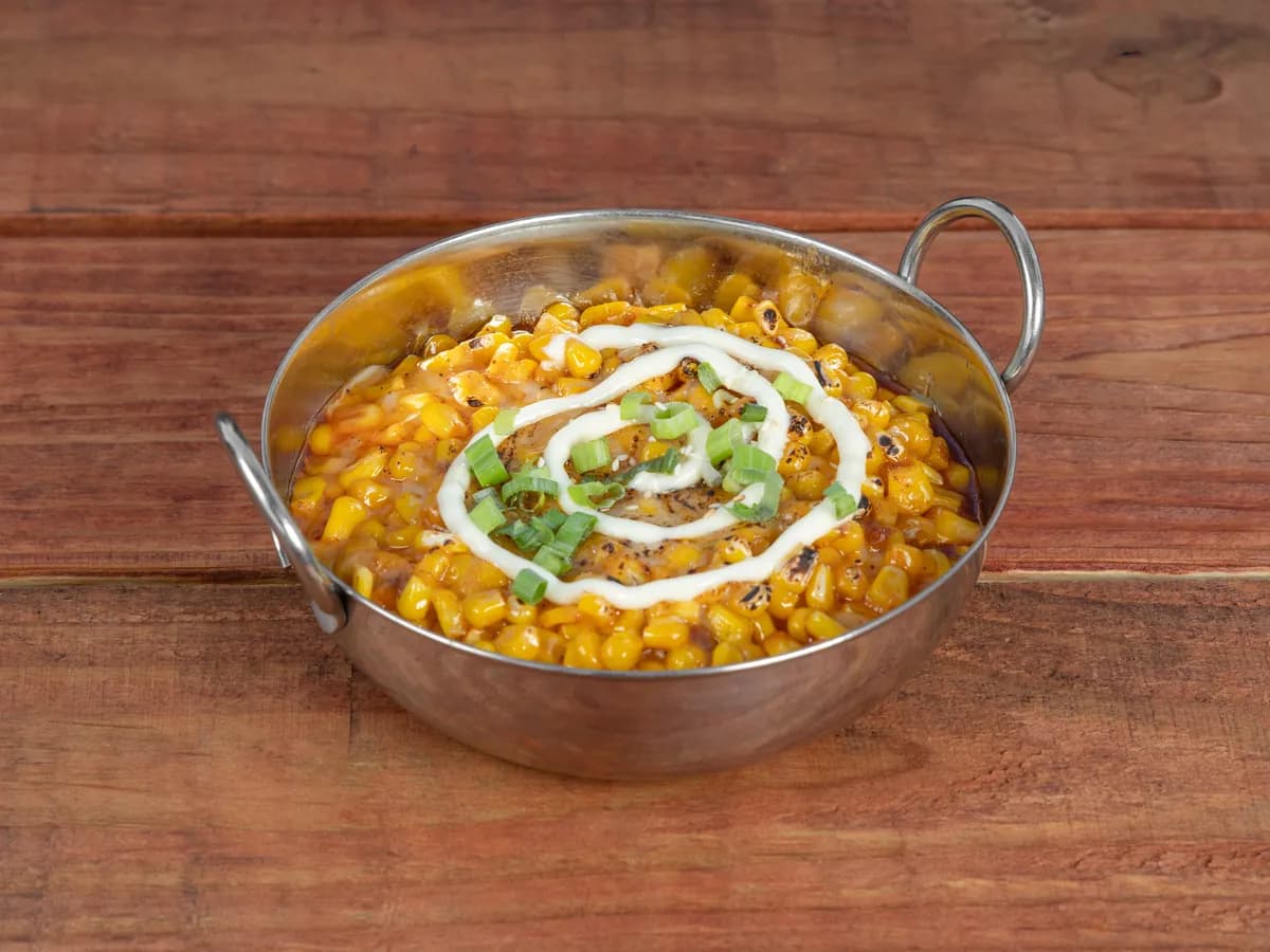 Corn cheese bubbling in a cast iron pan