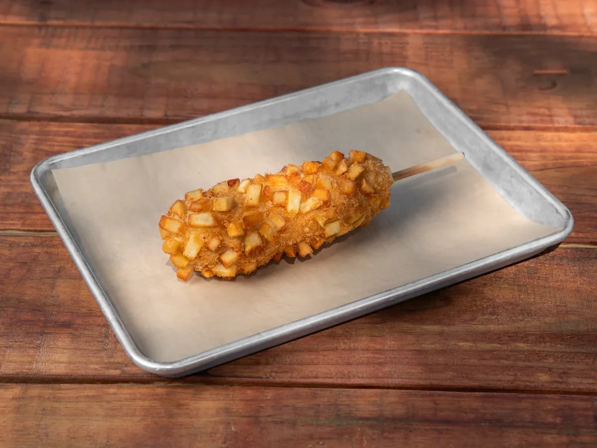 A Potato K-Dog covered in fried diced potato chunks