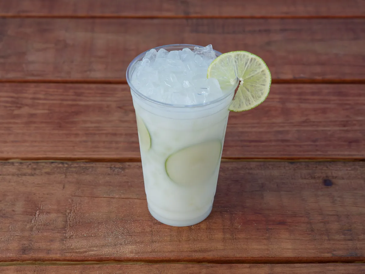 A Uyu Lime limeade over ice with a lime wheel